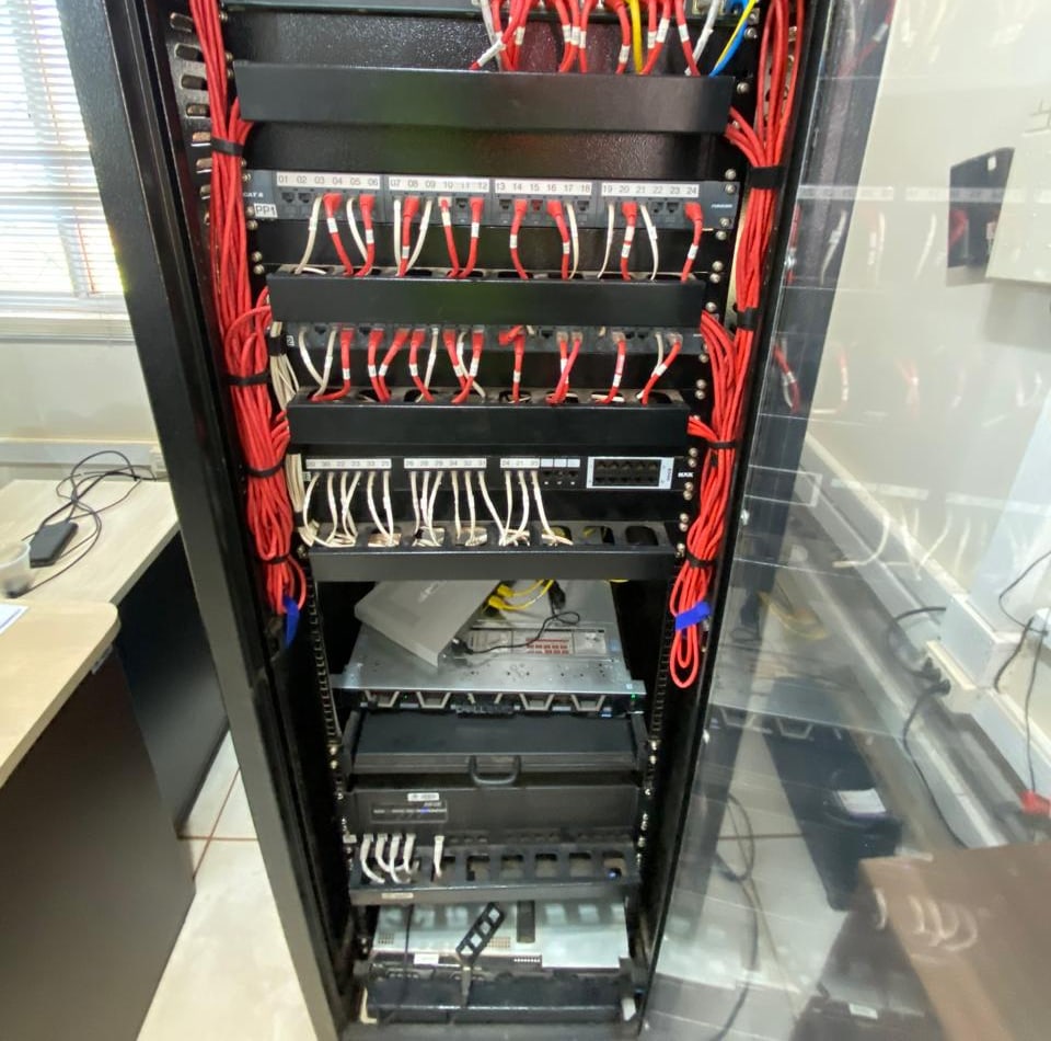 Equipamentos e cabeamento no interior de um rack de infraestrutura