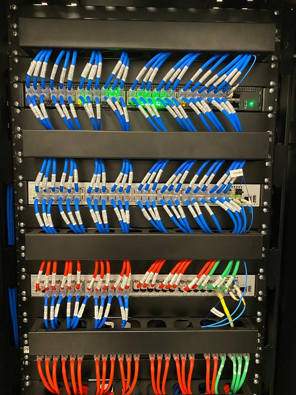 Patch panels e cabos organizados em um rack de rede