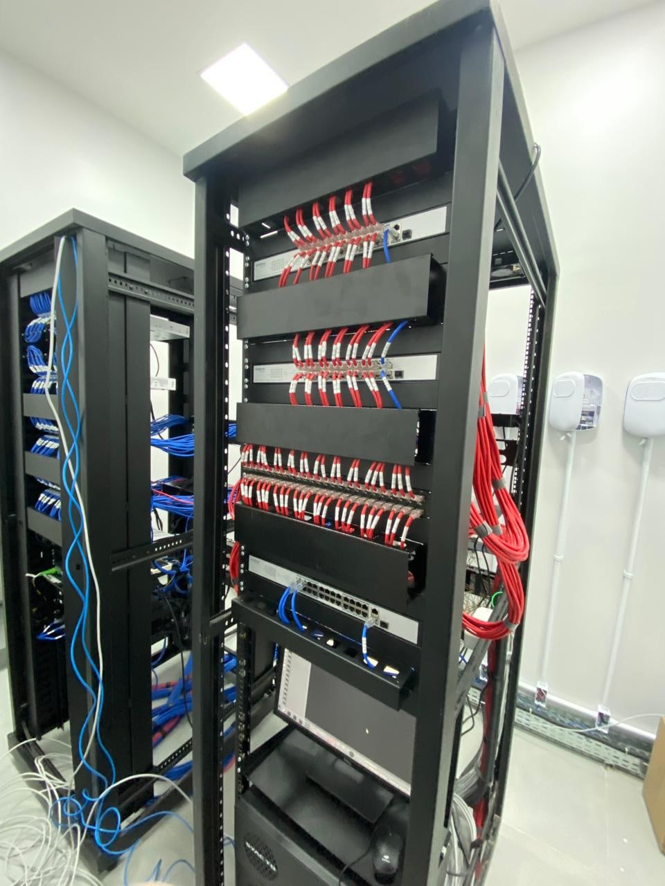 Racks com equipamentos e cabeamento organizados em um ambiente técnico