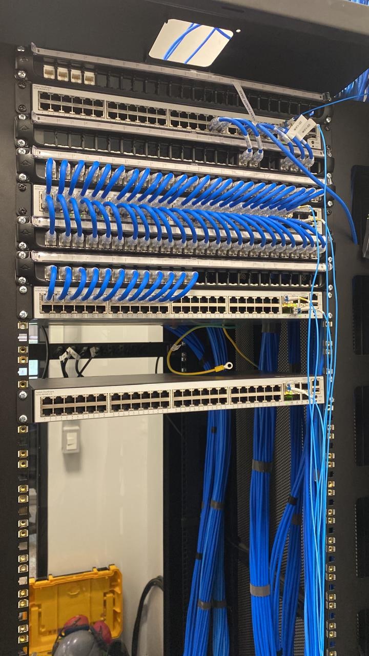 Switches, patch panels e conexões de rede com cabos azuis organizados